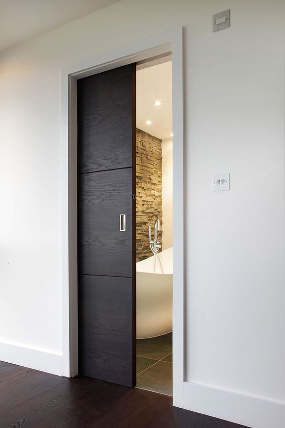 A small dark stained pocket doors leads to the bathroom and makes it look like a treasure