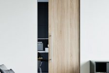 a small light-stained pocket door with sleek and long handle is a stylish way to separate the spaces ina  contemporary home