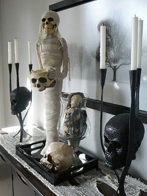 a stylish and scary Halloween decoration of a mummy, skulls and bones on a tray is a gorgeous idea to go for