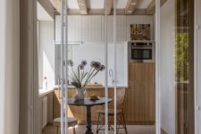 a super delicate white frame and glass folding door is perfect for subtle space separating and it matches the decor of the kitchen