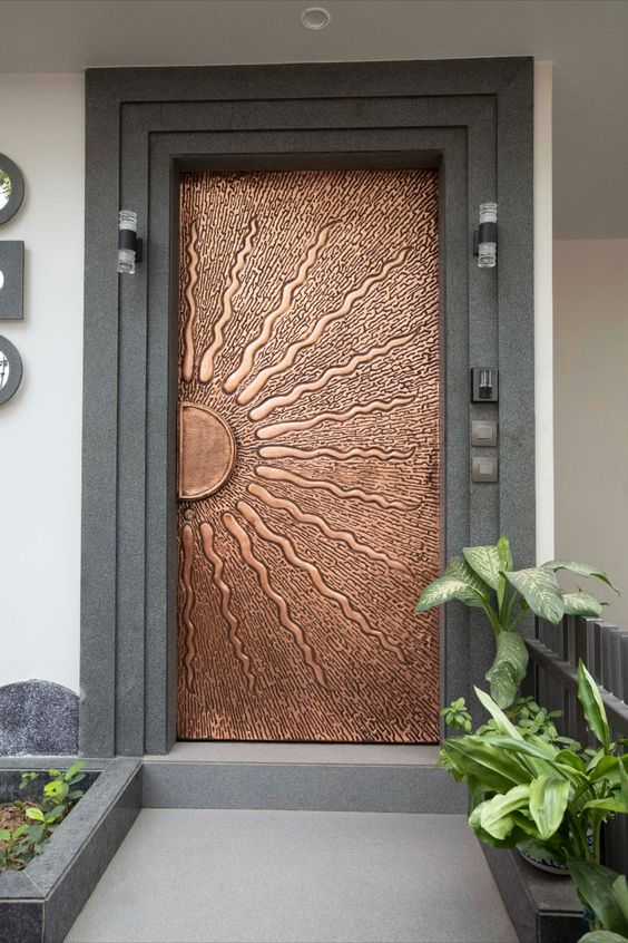 a unique copper door with a sun portrayed is a gorgeous idea to make a statement with its color and this image