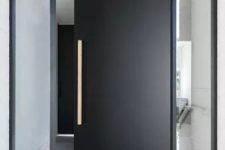 a very laconic and stylish matte black metal front door with a handle and long and narrow windows on each side is amazing