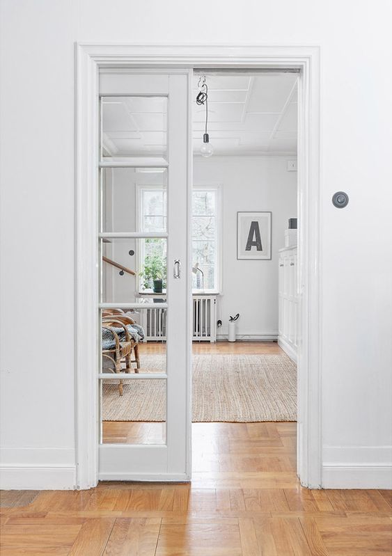 A white French pocket door separates the room and makes both spaces light filled at the same time