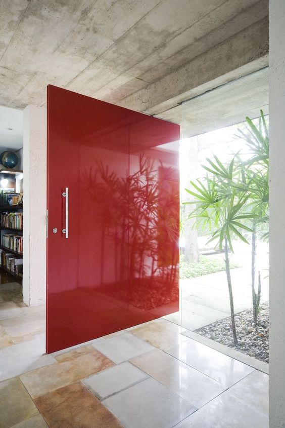 An oversized bold red super sleek front door with a usual handle is a fantastic idea for a mid century modern home