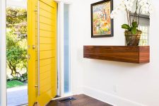 an oversized yellow planked square front door with oversized handles is a gorgeous idea for a modern or mid-century modern house