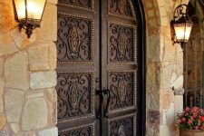 dark vintage-styled wrought iron front doors are perfect for a mansion or a large vintage house as they make a refined statement at once