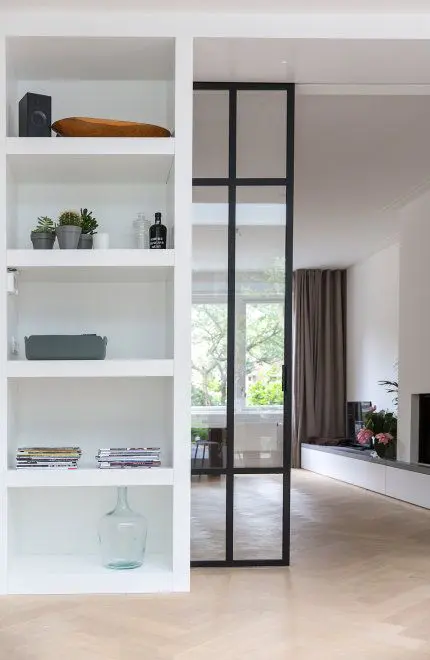 en elegant and chic black metal frame glass pocket door divides the space in a cool and stylish way without havy looks