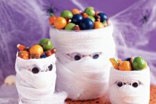 jars shaped as mummies with candies are perfect for kids’ Halloween parties are amazing to rock and can be easily DIYed