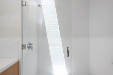 just a small skylight makes this white shower space bolder and chic and lets you enjoy sunlight as if you are having a shower outdoors