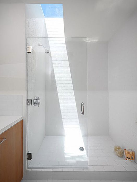 just a small skylight makes this white shower space bolder and chic and lets you enjoy sunlight as if you are having a shower outdoors