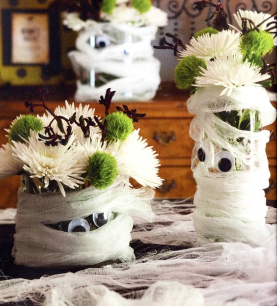 Mummy styled planters with white and green blooms are adorable as Halloween centerpieces or just decorations