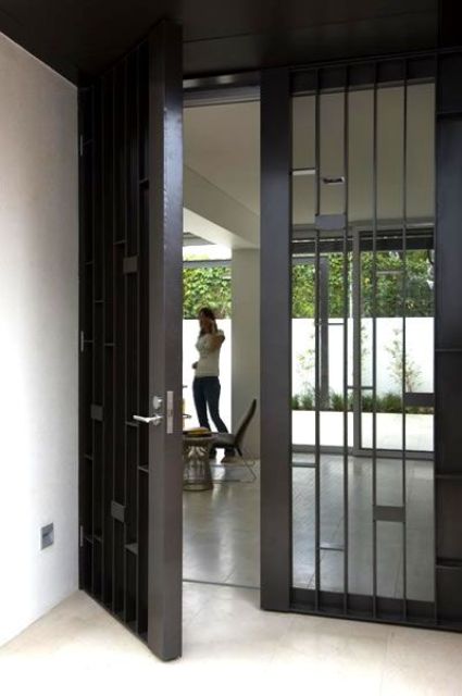 simple yet sturdy blackened steel and glass front doors are great for a modern home and they look catchy and bold