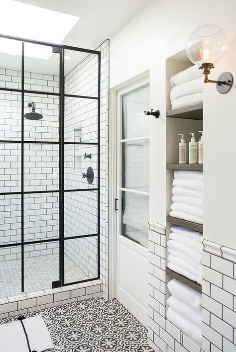 this white and black bathroom is made brighter with skylights over the shower and is filled with natural light easily