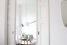 vintage-inspired white pocket doors separate the bedroom from the living room without wasting any space at all