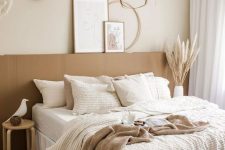 08 a dreamy boho lux bedroom in neutrals, with a bed with an extended headboard, a pendant lamp, woven baskets and neutral bedding