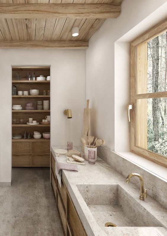 A gorgeous neutral kitchen with light stained cabientry, stone countertops and a sink, a wooden ceiling and a small pantry
