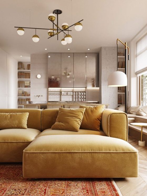 a beautiful minimalist space with silver kitchen cabinets and a mustard yellow sectional plus brass touches for elegance