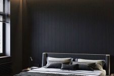 a black minimalist bedroom with a black wooden slab accent wall and built-in lights, a black floating bed with lights and monochromatic bedding