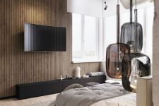 a fab contemporary bedroom with a wooden slab accent wall, a white floating bed with neutral bedding, a cluster of dark glass pendant lamps and a black TV unit