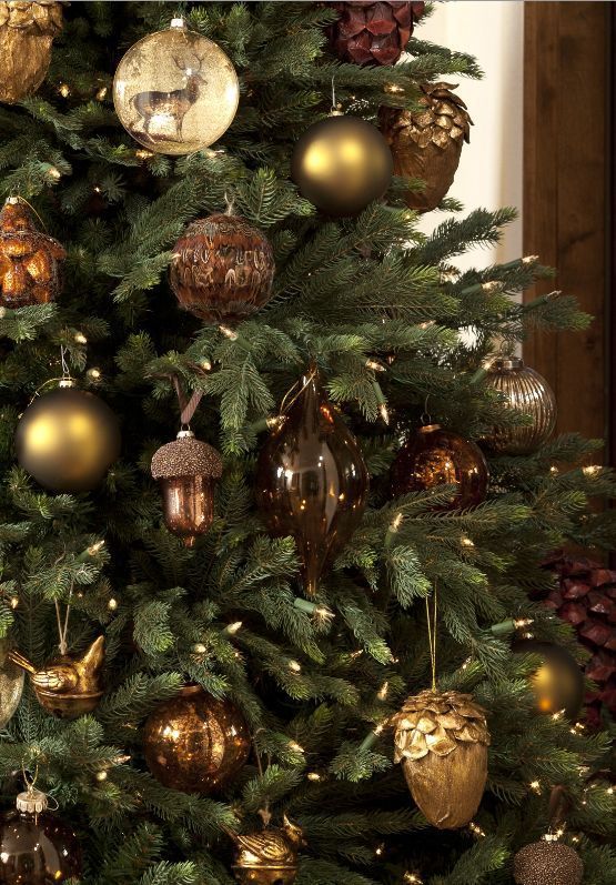 a cool forest Christmas tree with vintage brown, gold and beige ornaments shaped as balls, deer printed balls, acorns and pinecones is amazing