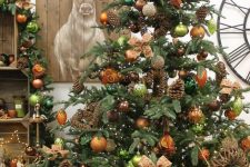 31 a fabulous woodland glam Christmas tree with copper, orange, light green ornaents, pinecones, vines and vine decorations is amazing