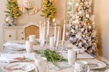 35 a refined woodland glam Christmas tablescape with silver placemats, printed plates and mugs, wood pinecones and bells plus a modern candelabra is wow