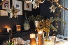36 a woodland glam Christmas tablescape with shiny candleholders, greenery and a catchy chandelier made of a tree branch with lights, star and ball-shaped ornaments