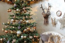 38 lovely woodland glam Christmas decor with a tree with gold, brown and pearly ornaments, deer heads, ornaent garlands and vine trees