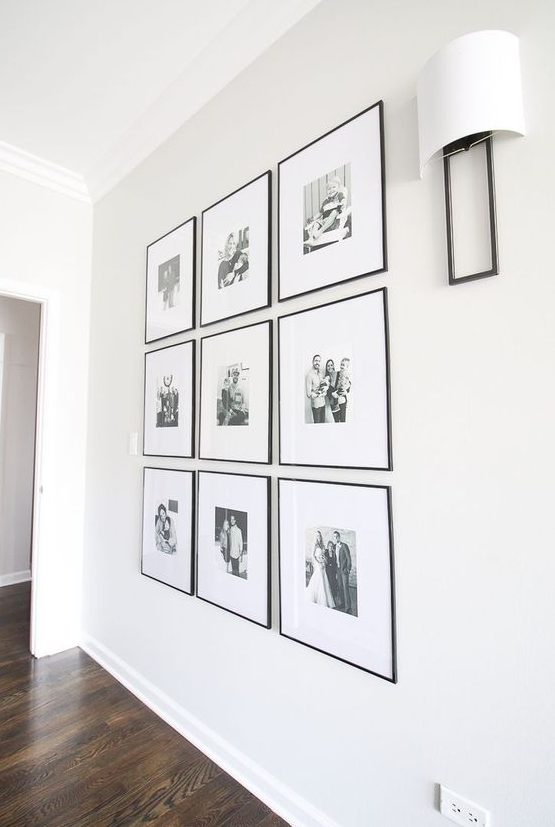 a chic and elegant grid gallery wall with black and white family pics and thin black frames is an adorable solution