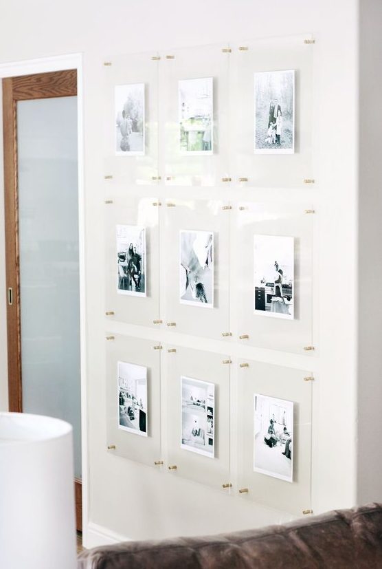 A floating gallery wall with clear acrylic frames and gold pins is a stylish idea that looks ultra modern and outstanding