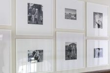 a modern grid gallery wall with white frames and black and white family pics plus white matting is fresh