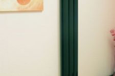 a narrow dark green radiator is a bold and contrasting accent for any interior and it will look very eye-catchy
