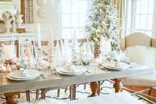 a winter wonderland Christmas tablescape with lots of candles, elegant white porcelain and faux fur around