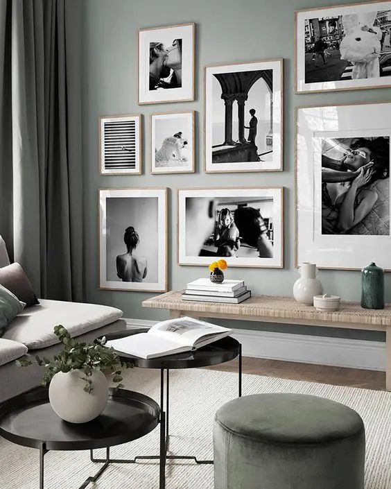 An eye catchy black and white gallery wall with a free form and light stained wooden frames for a more interesting look