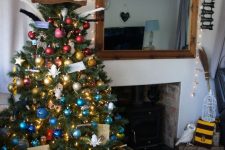 03 a colorful Christmas tree decorated with bold ornaments, lights, stars, letters and a Sorting Hat tree topper is wow