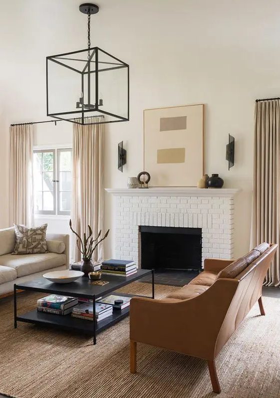 an elegant living room done in the sahdes of beige and camel plus black details for depth