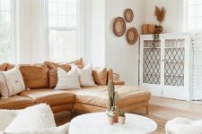 10 a welcoming boho living room with dark beams, an amber leather sofa, white furniture and decorative baskets on the wall