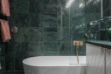 16 green marble tiles covering the whole bathroom make it a refined and a bit moody space