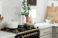 19 an elegant black cooker and some gold touches add drama and chic to the neutral kitchen with a vintage feel