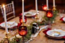 23 a pretty and chic Harry Potter Christmas tablescape with tall and thin candles, mini ornaments and greenery, elegant porcelain and red napkins