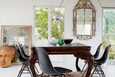 33 a gorgeous dining room with a vintage dark-stained dining table, modern black chairs and a bold accent rug