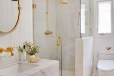 44 a chic and glam white bathroom with white tiles, a white marble floating sink and touches of gold for a shiny look