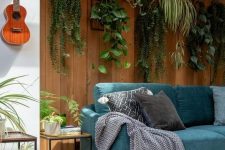 53 a biophilic living room with potted plants suspended over the sofa to the natural wooden wall
