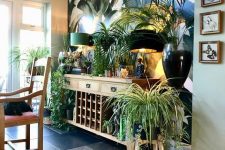 55 a biophilic space with potted greenery and plants, with a tropical print wall and wooden furniture