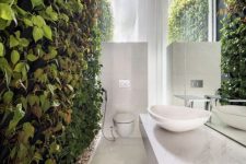 59 a truly biophilic bathroom done in neutrals and with a living wall and pebbles on the floor for a natural touch