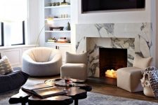 a beautiful and catchy modern living room with a built-in white marble fireplace, a built-in TV, built-in shelves, white and grey furniture and a wood slice table