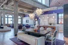 a fantastic refined open layout with periwinkle and white exquisite furniture, whimsical chandeliers and elegant floor lamps just wows