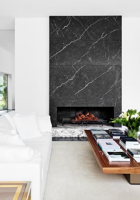 a luxurious living room with white and wooden furniture and a grey and white marble fireplace is a stylish and cool space