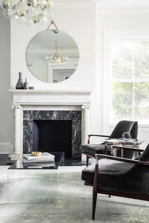 a modern luxurious living room in a monochromatic color scheme, with a fireplace clad with black marble and a white marble mantel