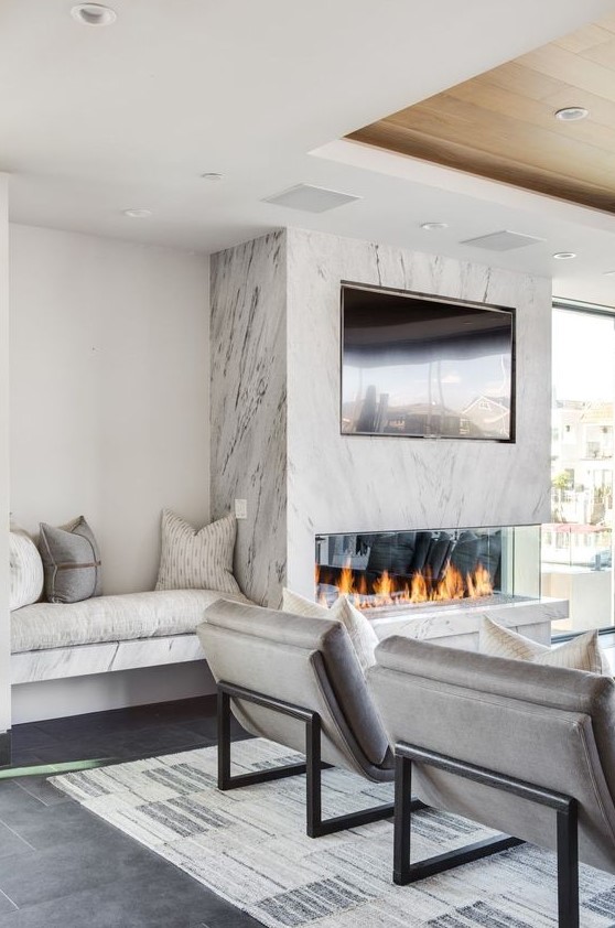 a neutral living room with a marble fireplace and a TV over that is a real centerpiece of the whole space